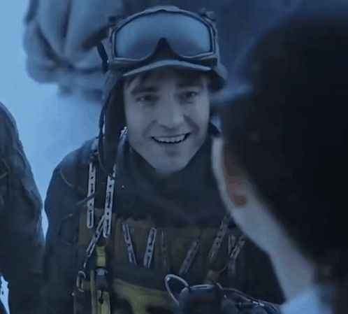 a man wearing a helmet and goggles is holding a yellow sign that says ' n ' on it