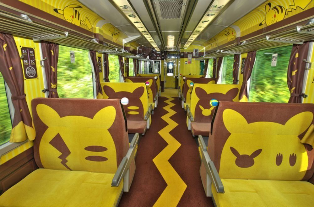 Photo of the inside of a pikachu themed train with pikachu themed designs and seats 