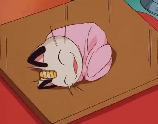 Screenshot of meowth in the Pokémon anime curled up for a nap in a pink blanket 