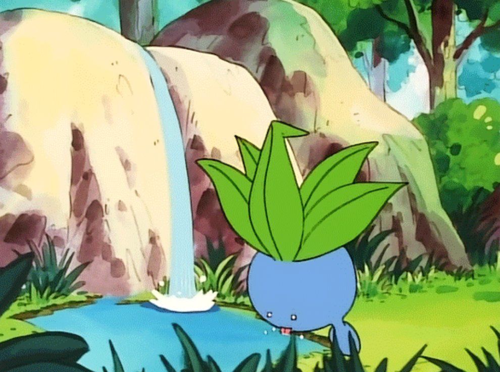 Screenshot of oddish on grassland at the edge of a small pool of water taking a drink from it in the pokemon anime 