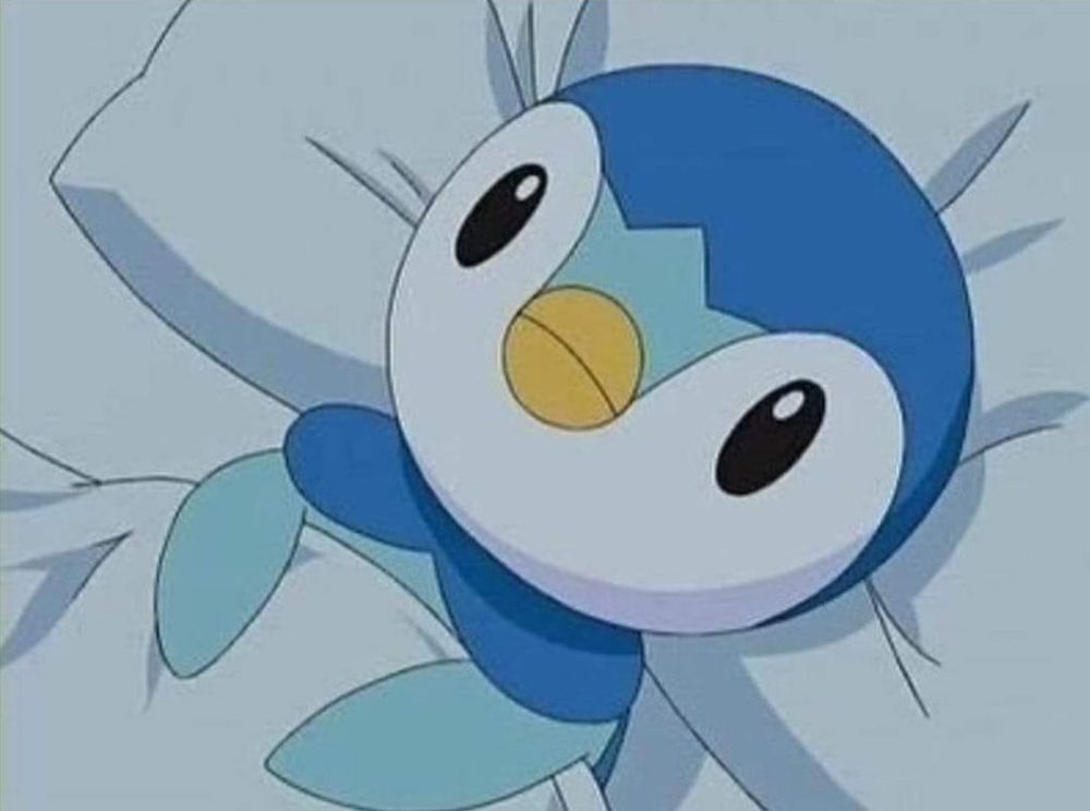 piplup laying in a bed in the pokemon anime with eyes wide open