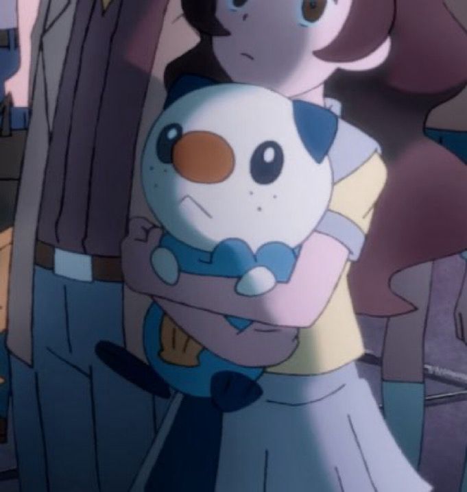 Screenshot of a girl holding her oshawott in the Pokémon anime 