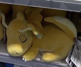 picture of a sleeping dragonite plush on a store shelf 