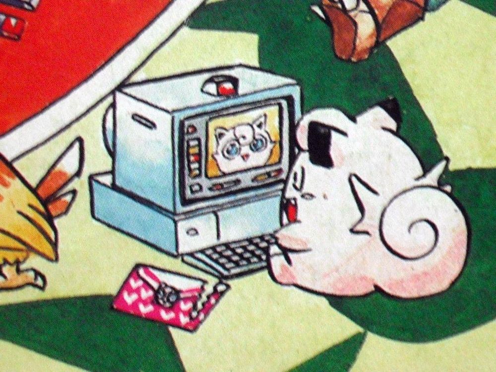 Photo of a Pokémon picture book showing clefairy talking to a jigglypuff through a computer 