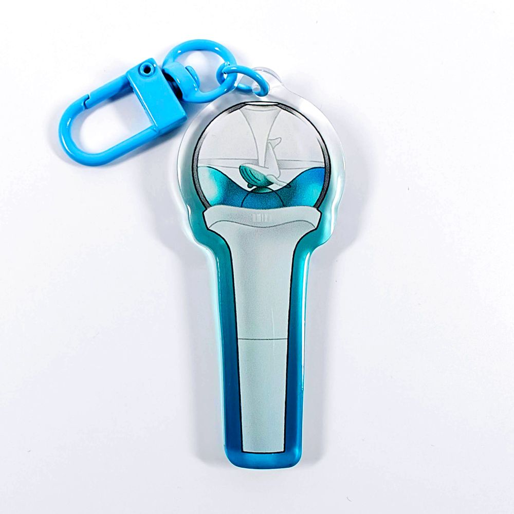 A picture of an acrylic keychain of a drawn version of NMIXX's newest lightstick. The rim of the keychain has an ombre that goes from blue at the bottom to clear at the top. It has a light blue clasp.