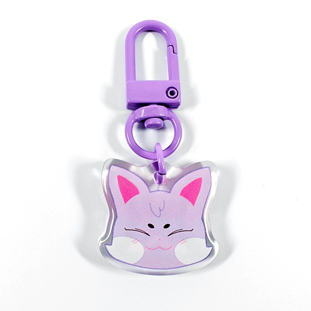 A picture of an acrylic keychain of San's Aniteez animal from the K-Pop group ATEEZ. It's the head of the cat smiling like his original design. The rim of the keychain is clear. It has a purple clasp.