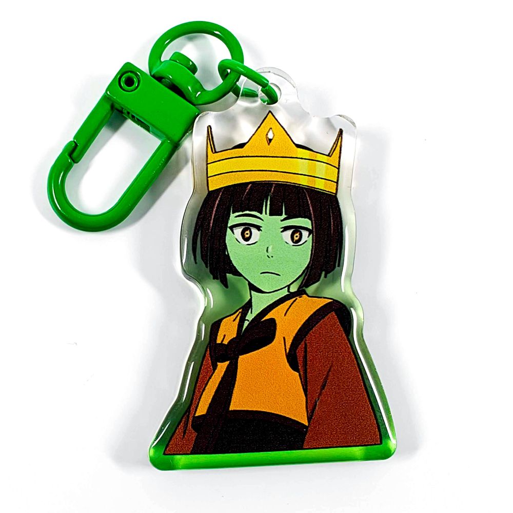 A picture of an acrylic keychain of Anaak from Tower of God. She looks shocked, wearing a gold crown and her classic outfit. The rim of the keychain is a gradient going from green at the bottom to clear at the top. It has a bright green clasp.