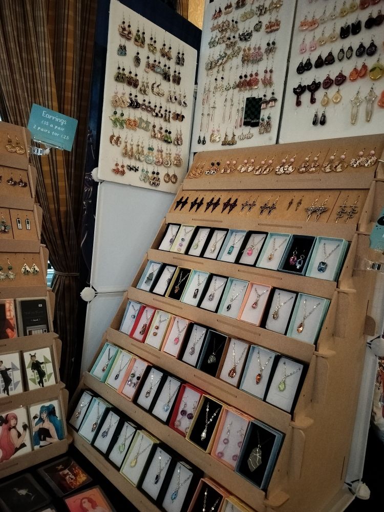 A close-up of the right side of the tables where you can see pendants, earrings and photocards.