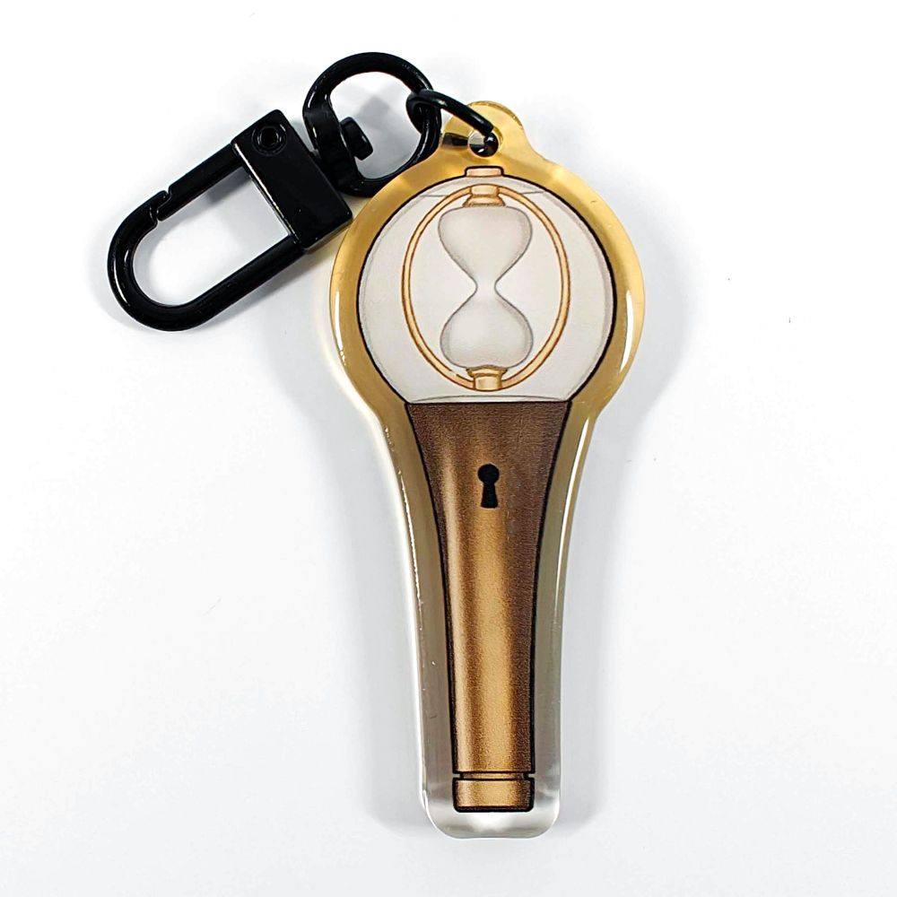 A picture of an acrylic keychain of a drawn version of ATEEZ's newest lightstick. The rim of the keychain has an ombre that goes from clear at the bottom to golden at the top. It has a black clasp.