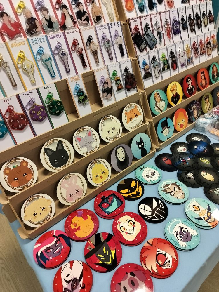 A close-up picture of the table at Teesside Comic-Con. You can see the keychains and coasters from the previous pictures closer.