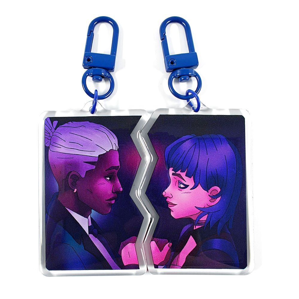 The same illustration from before of Ekko and Powder from Arcane looking at each other. This is a picture of 2 keychains, showing Ekko on the left and Powder on the right. The 2 keychains slot into each other in a lightning shape, to form the full illustration. They have dark blue clasps.