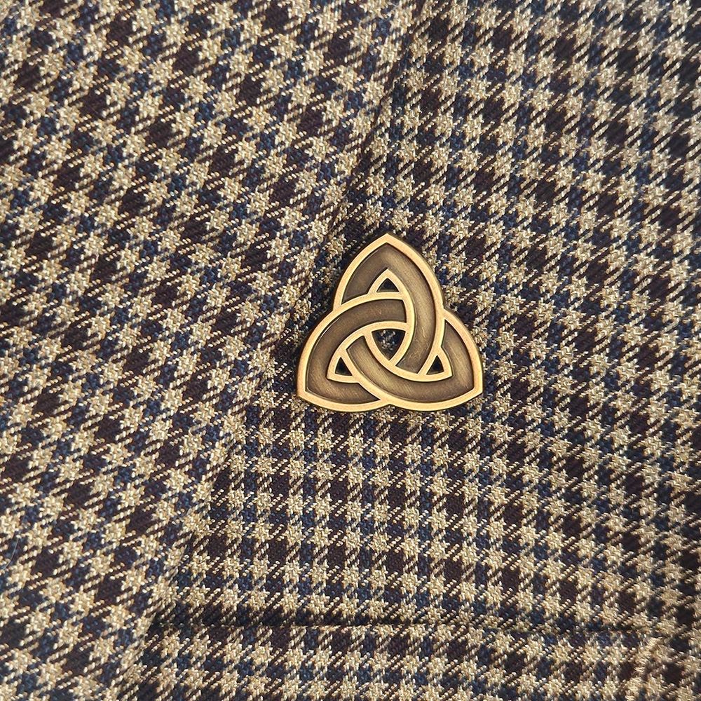 A celtic knot enamel pin made with two-tone antique-gold