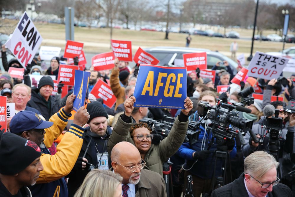 A photo of protestors in front of the Department of Labor, with an AFGE union sign.