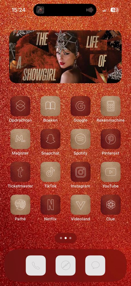 A screenshot of my homescreen with a glittery orange background. There’s a big widget of red taylor swift on top and it says ‘the life of a showgirl’ scattered in gold glittery letters. The app icons are glittery red and gold in a checkered pattern 