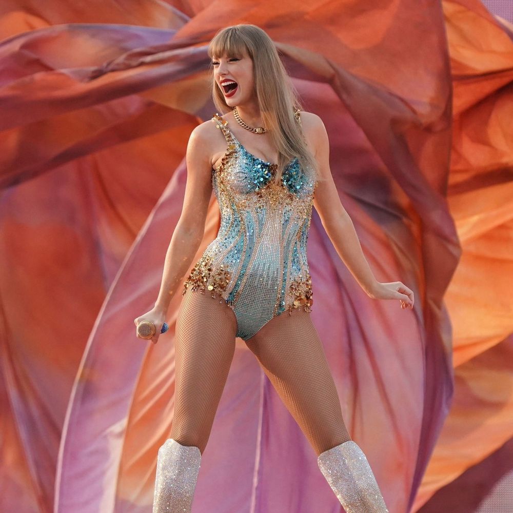A picture of Taylor swift on the eras tour in her blue and gold lover bodysuit right when the show starts