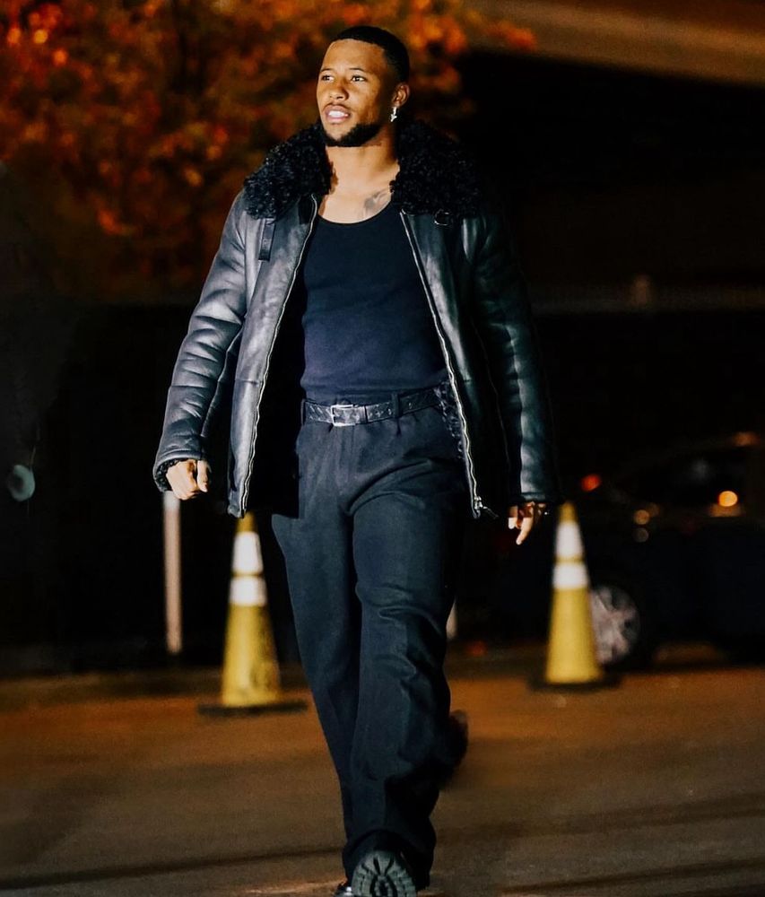 Saquon Barkley arrives for gameday in an all-black outfit featuring a leather jacket with a furry collar.