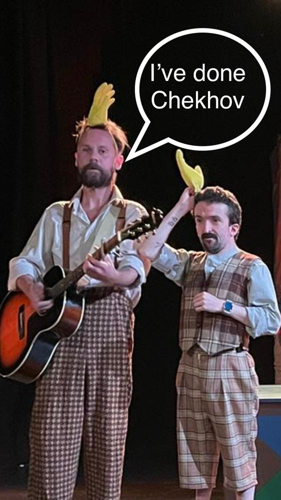 Sam and Macsen with marigild gloves on their heads because they’re playing chickens. speech bubble reads “i’ve done chekhov”.