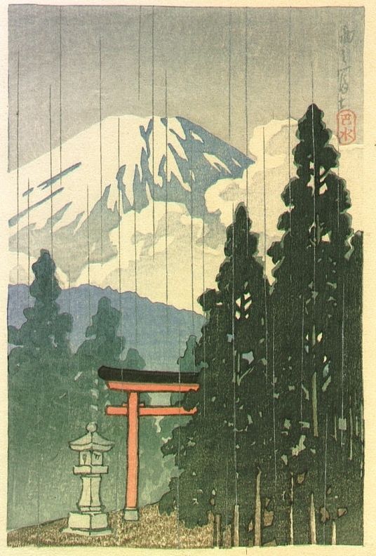 A landscape scene on a rainy day. A red torii and stone lantern stand beside trees with Mount Fuji in the background. 
