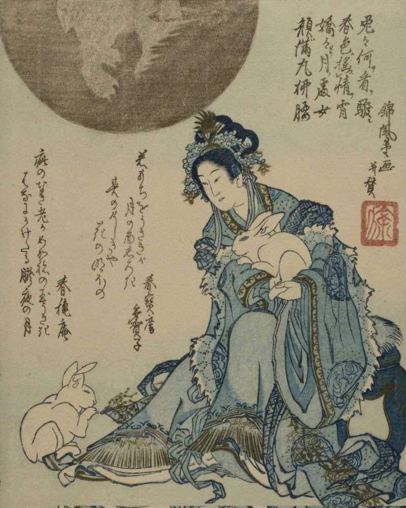 A woman dressed in blue holds a white rabbit on her lap and there is another near her feet. A large moon is behind.