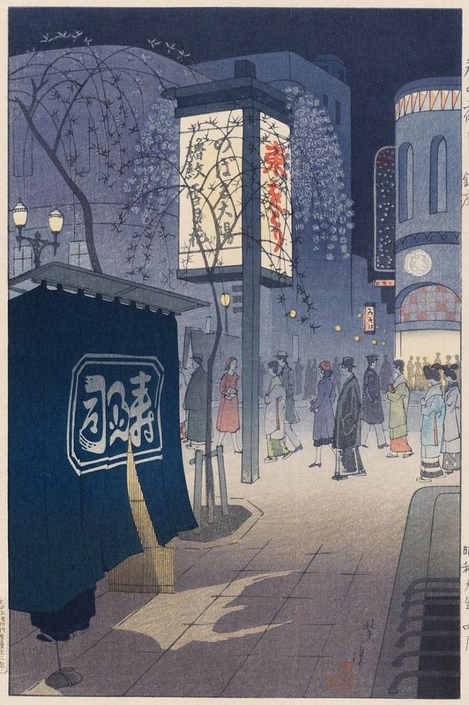 A street scene at night, people walking and cherry blossoms.