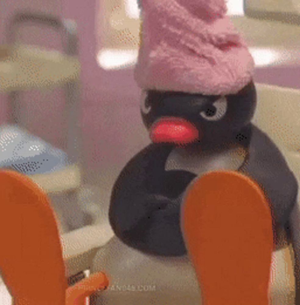 a penguin wearing a pink hat is sitting on a chair .