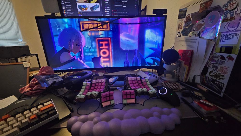 Same desk but showing the monitor as well. Also a computer case covered in gaming and anarchist stickers