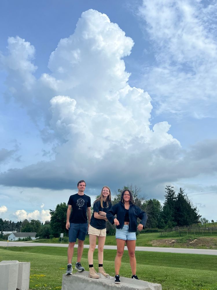 Three people standing in front of a cloud 