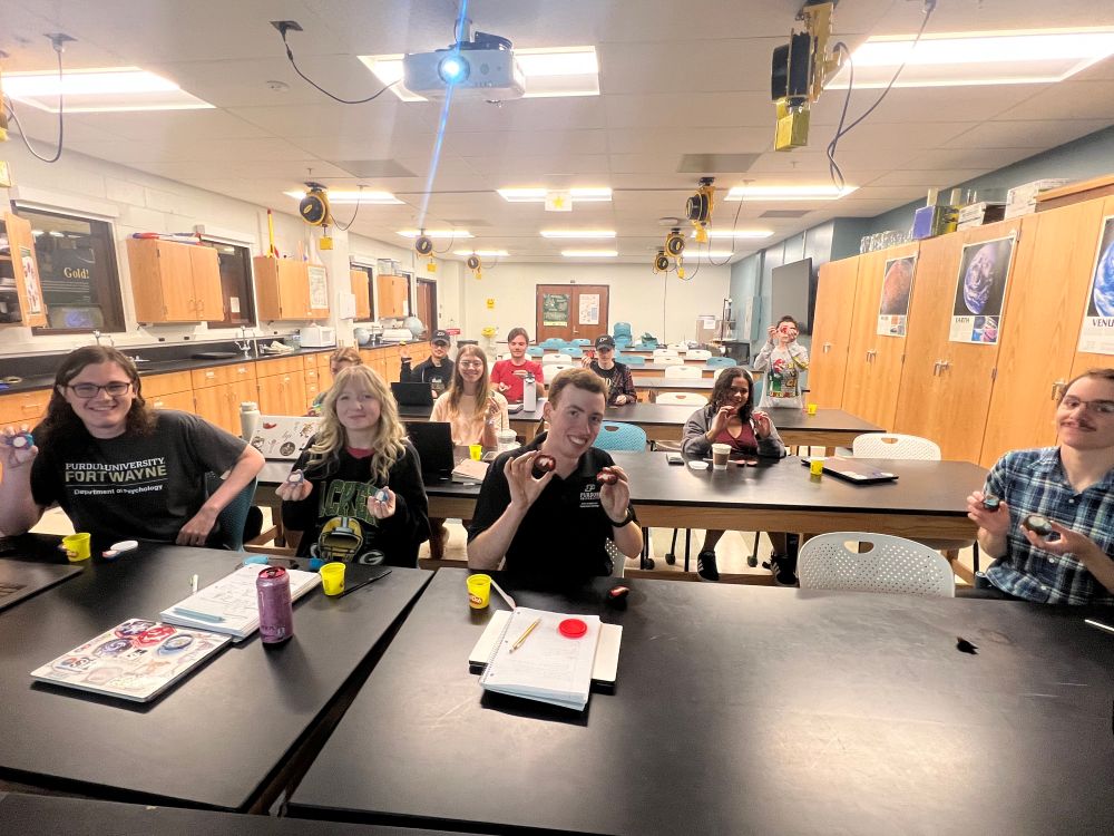 A classroom full of students holding up globs of play dough