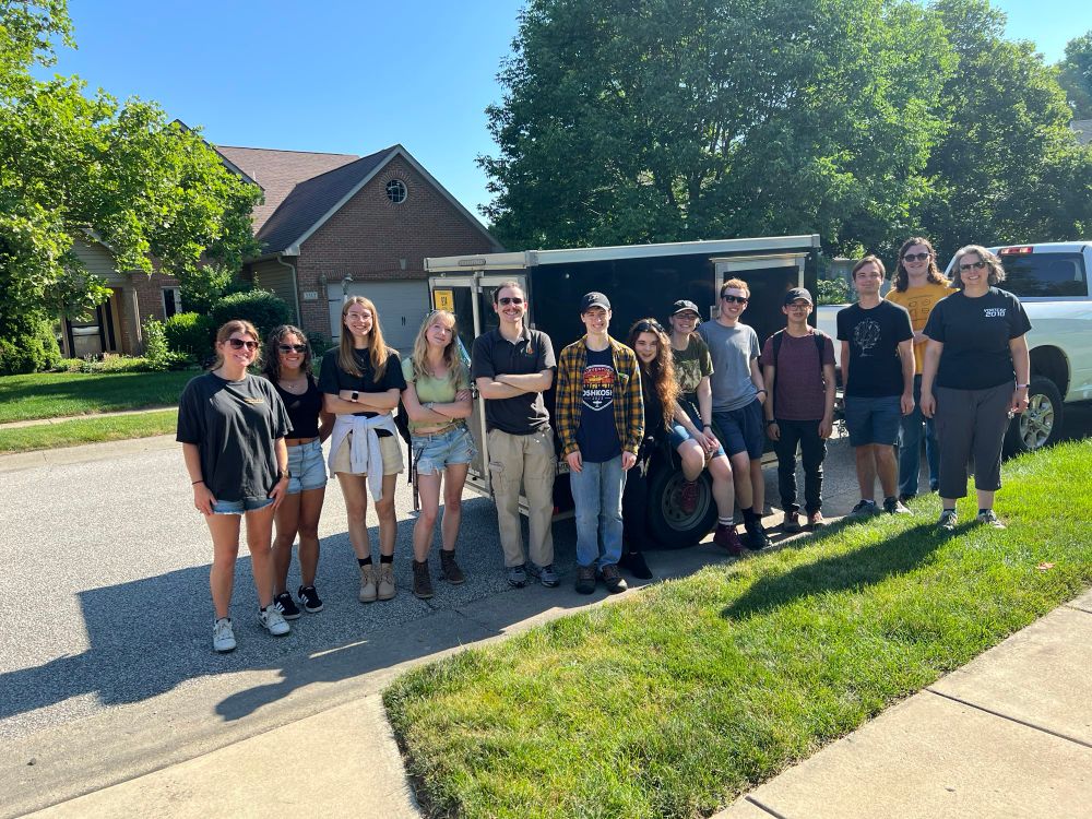 A group of people standing in front of a trailer.