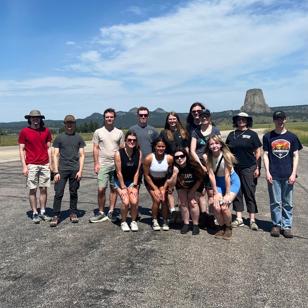 A group of people in front of Devils Tower in Wyoming 