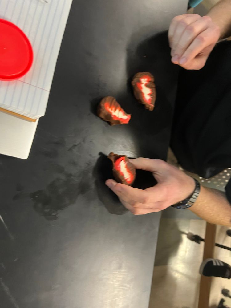 Three hunks of play dough on a table, with colors fading from brown to red to white in the middle.
