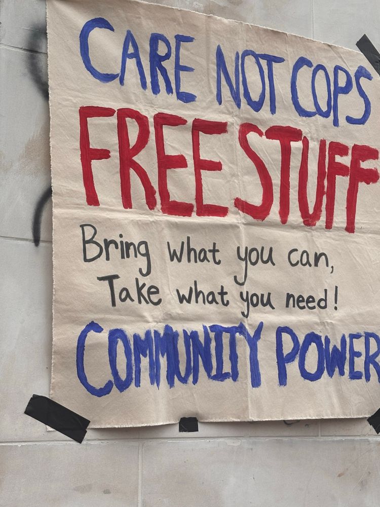  white canvas painted with red and blue letters that say “CARE NOT COPS
FREE STUFF
Bring what you can, Take what you need!
COMMUNITY POWER”