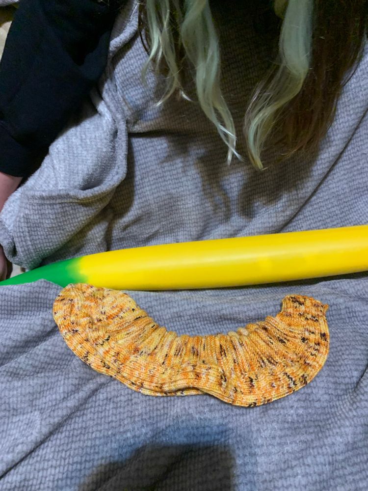 My kid is stretching the eldritch horror banana to a small fraction of its full length, while the banana socks are showing off their natural curves beneath.