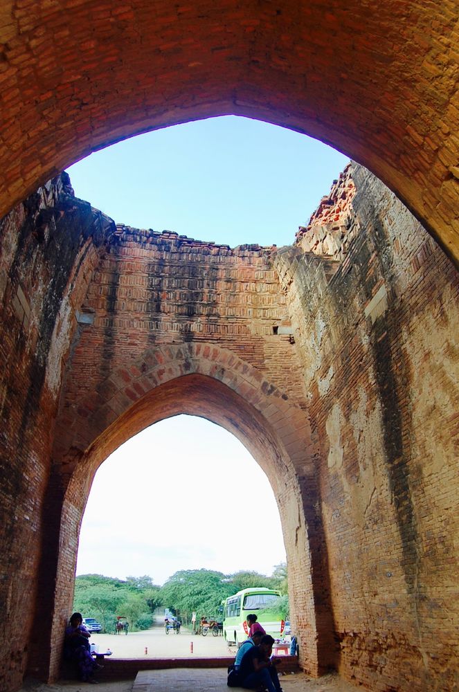 A dome-like entrance to a Buddhist temple in Bagan, Myanmar. The roof is open giving pilgrims and visitors a look at the sky. Souvenir sellers are waiting at the entrance. My Bagan travel is one of my most unforgettable journeys in Myanmar.