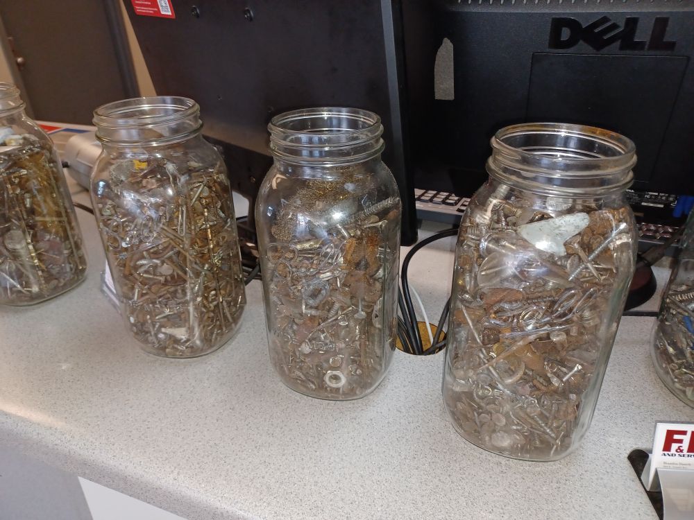 Mason jars full of nails, screws and other rusty junk.
