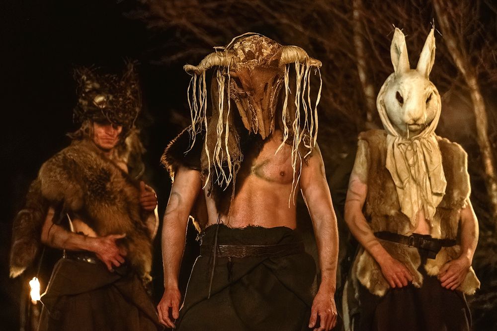 Three hot dudes dressed in just brown kilts, fur wraps, and animal masks in OUTLANDER: BLOOD OF MY BLOOD Episode 5