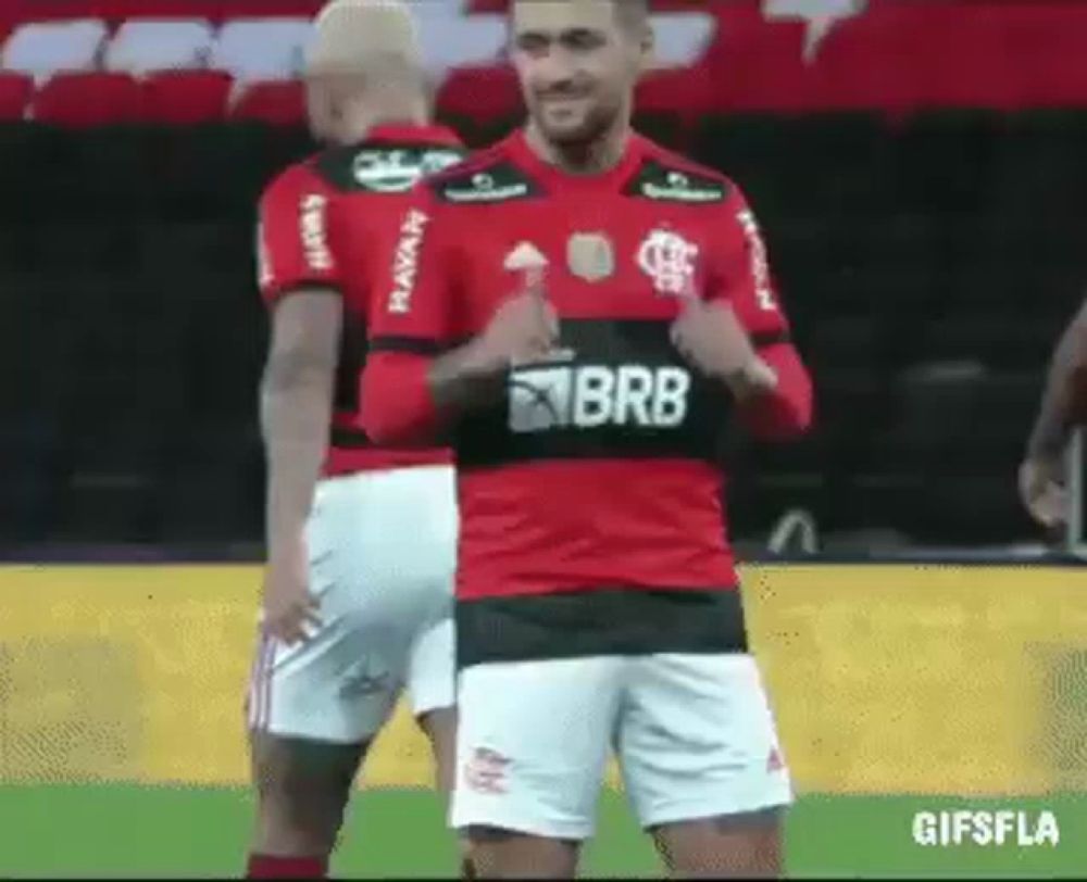 a soccer player is giving a thumbs up while standing next to another player on a field .