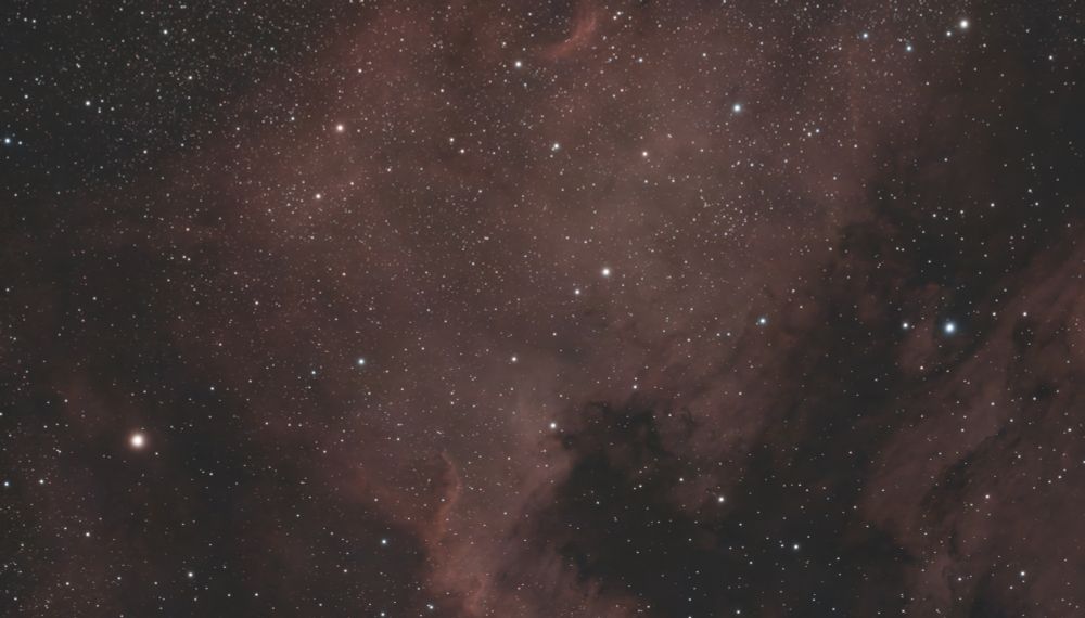 Reddish nebulosity in the rough shape of North America. A field of view of ~2.9 X 1.6 °