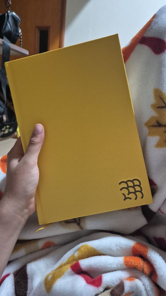 capa do livro "o palácio de papel". a capa é toda amarela, com o símbolo do clube intrínsecos na margem de baixo, à direita. 