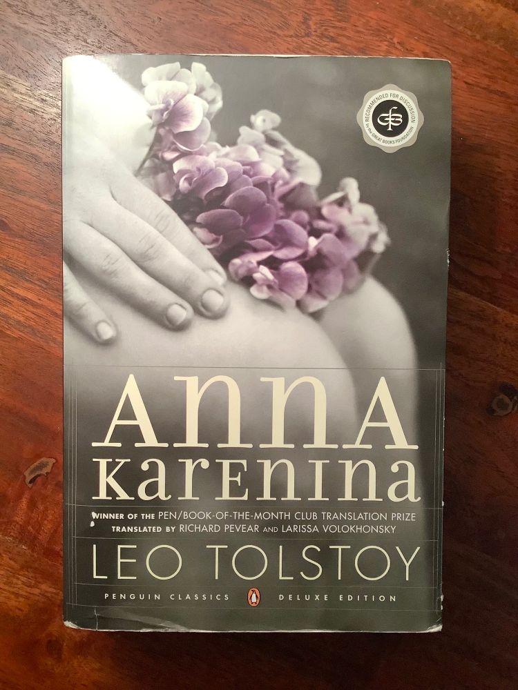 Copy of Leo Tolstoy’s novel, Anna Karenina, the Pevear / Volokhonsky translation.

Image features a close-up of flowers held on someone’s lap.