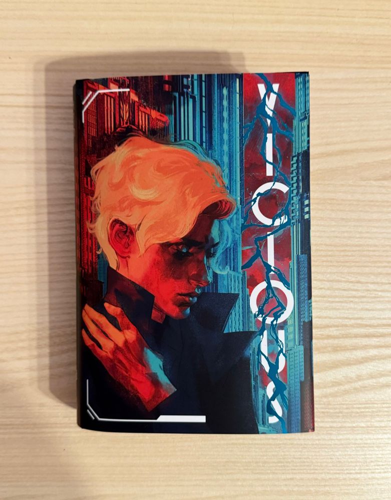 new edition of Vicious by ve schwab with cover painted by me of victor looking sexily pensive in front of an art deco cityscape lit by lightning