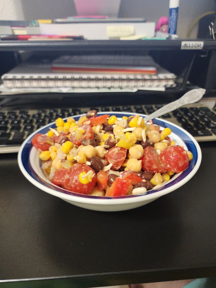 A bowl filled to the brim with bean and veggie salad 
