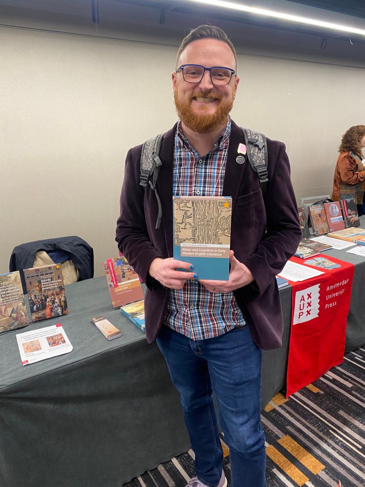 Nic Helms holds up their book 