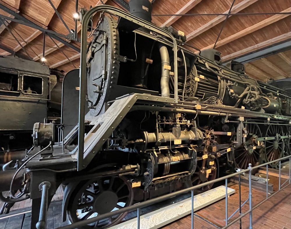 A big black 4-6-0 express locomotive that has the cylinders, valves, smoke box, fire box, boiler, fire tubes, superheater tubes and steam dome all sectioned to reveal what’s inside. 