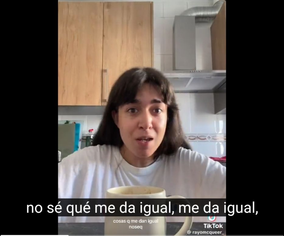 La tiktoker Rayo McQueen que se hizo muy popular con cosas NORMALES que hacía en su cafetería, pero que hemos dejado de considerar normal en un tardocapitalismo que vincula todo comportamiento humano con un cambio económico. En la imagen es una frame quieto del vídeo popular de Rayo McQueen donde ella cuenta como en la cafetería donde trabaja deja a la gente poder ir al baño y cosas así, y se ve un pantallazo de su cara con su cuenta de Tiktok en el identificador de Tiktok, pues es una imagen de ese vídeo, y en ella los subtítulos dicen "no sé qué, me da igual, me da igual"