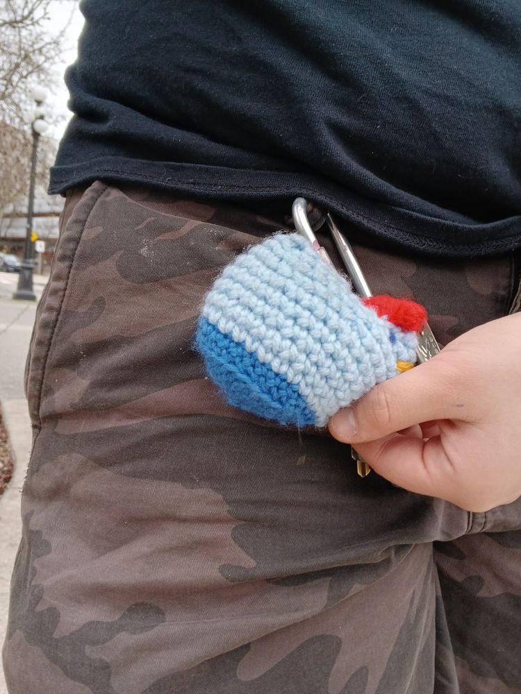 Crocheted Blue Chicken on a Carabiner attached to Camo shorts