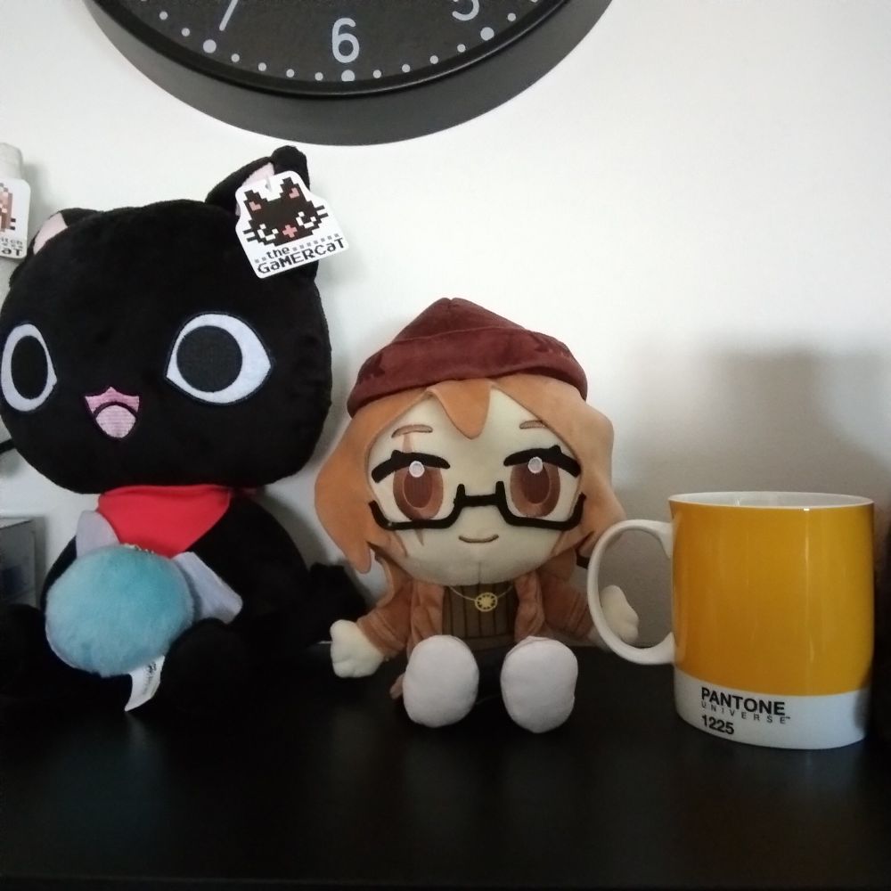A plushie of the vtuber Clio Aite sits on a shelf, with a mug positioned to look like Clio is holding it