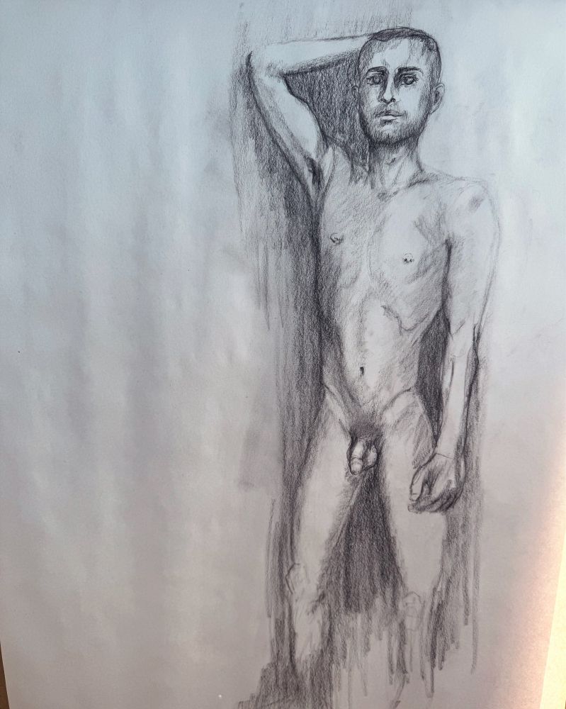 A fine art charcoal drawing of young nude male standing facing the viewer with his right hand behind his head