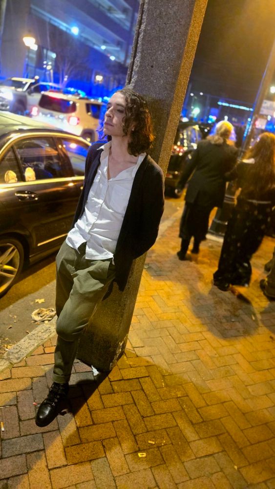 Pic of me leaning on a lamppost wearing a blue cardigan and white button down