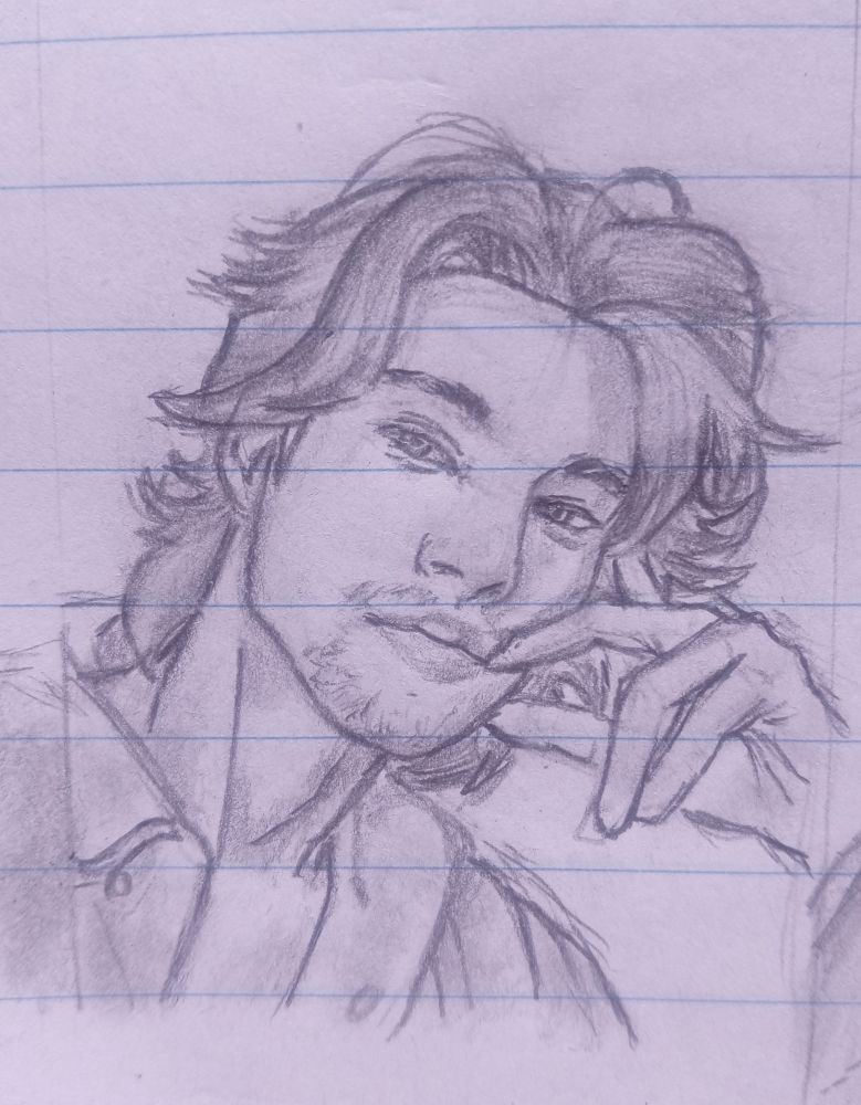 Pencil drawing of a relaxed young man with slightly tousled medium-length hair and subtle facial hair. He leans his head on one hand with a soft smile and a calm, confident gaze.